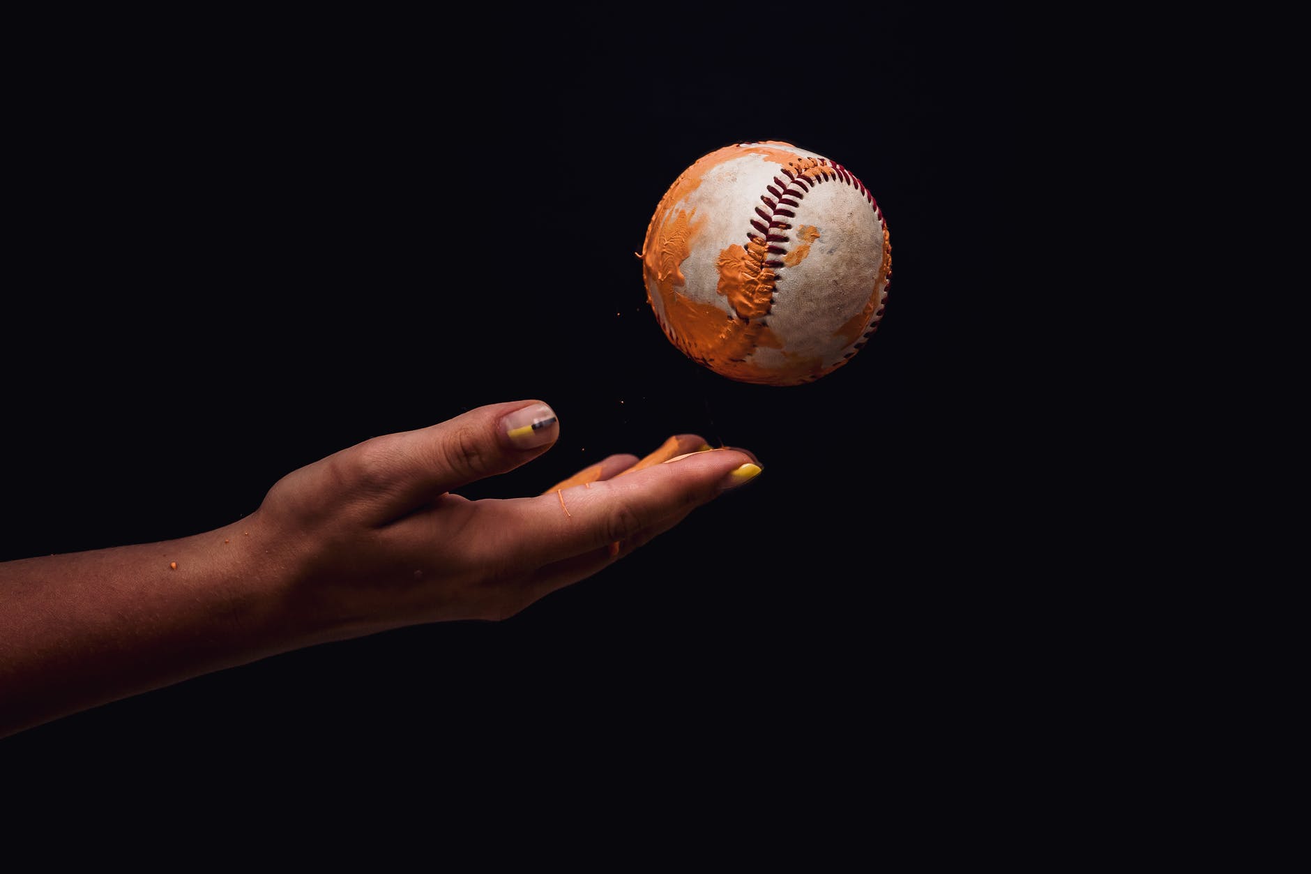 photo of person s hand throwing a baseball